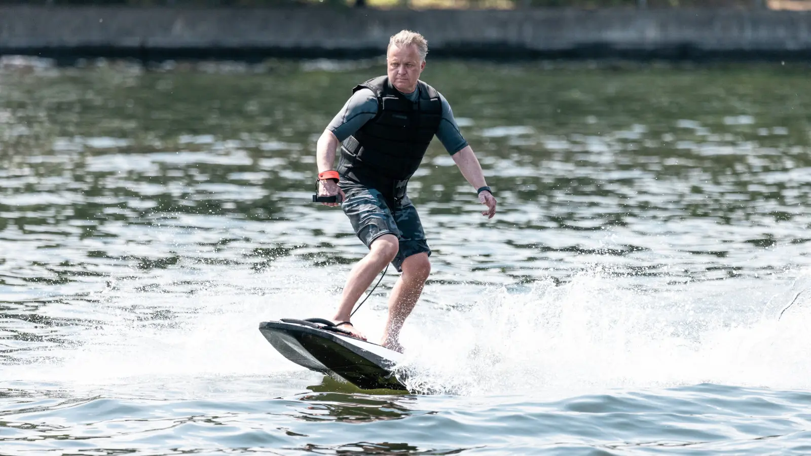 Andreas Lakeberg von E-SURFER fährt ein Awake Rävik Jetboard mit Handcontroller über das Wasser