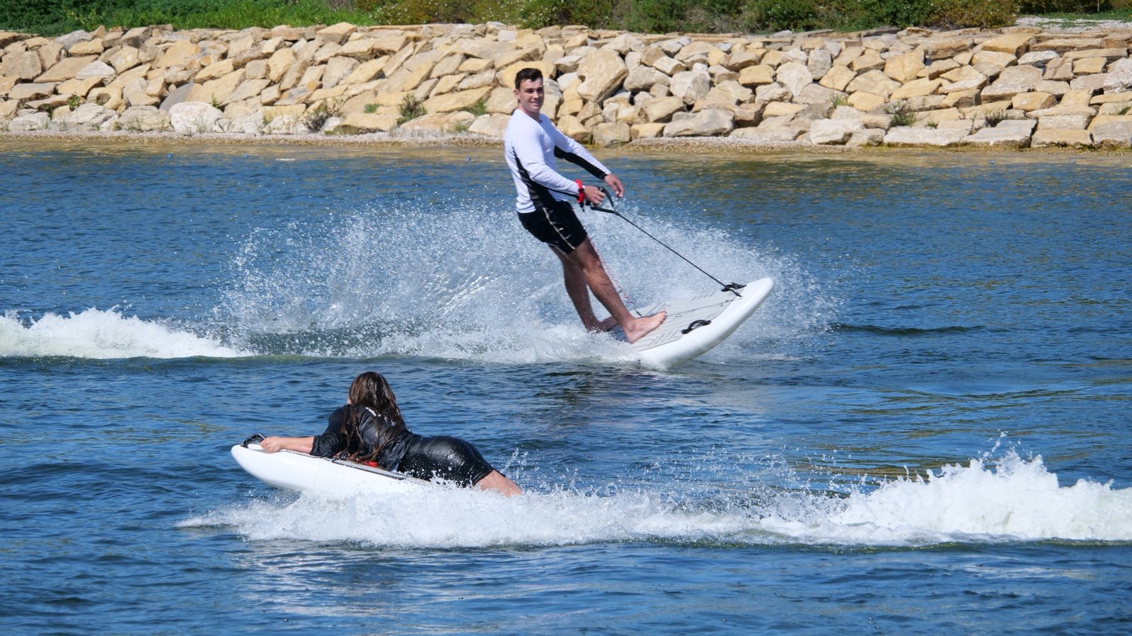 Fahrer auf dem mo-jet Surf und Fahrerin auf dem mo-jet Bodyboard auf dem See im La Reserva Club Sotogrande